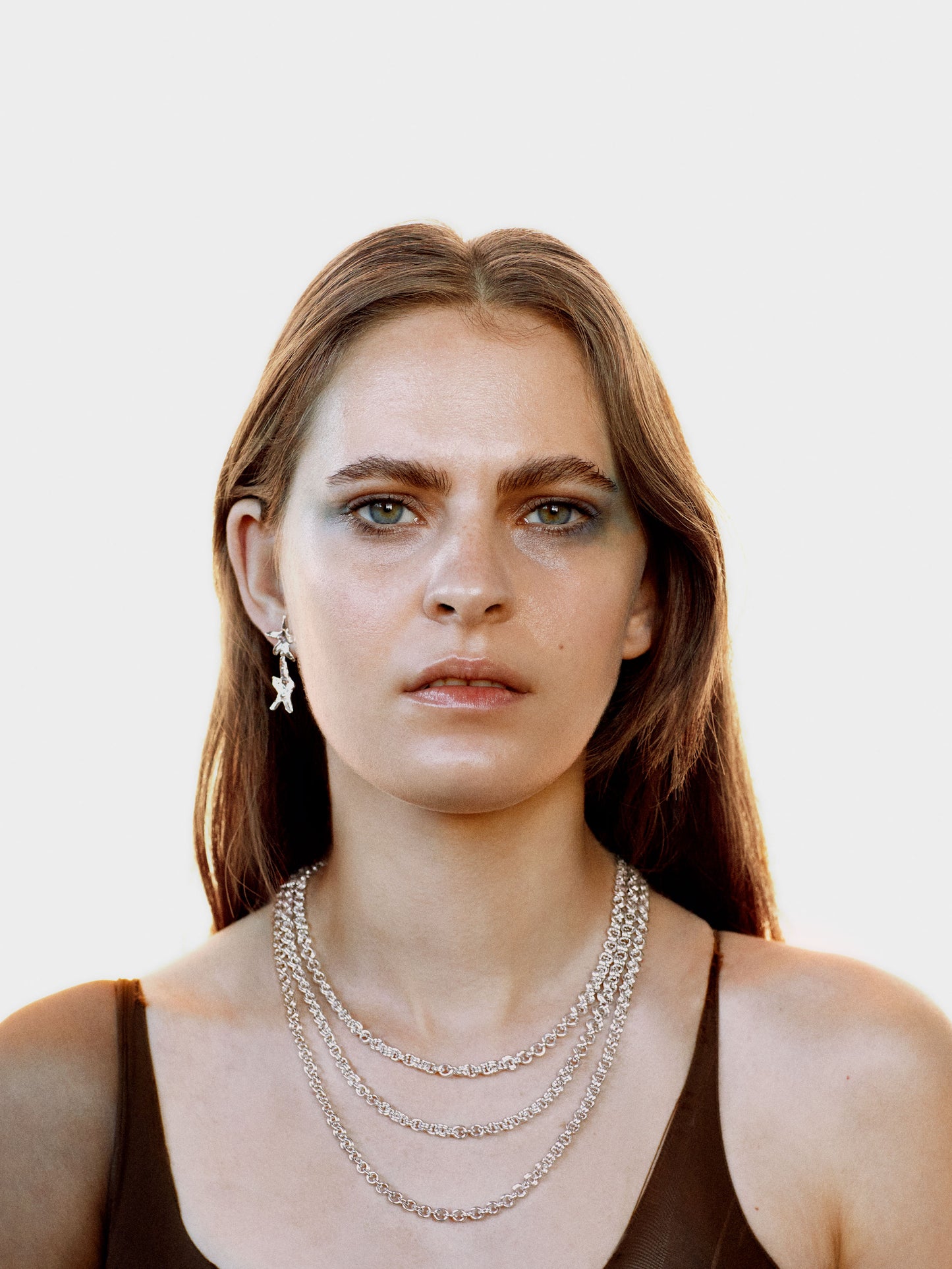 Coming Age Dawn collection campagne image of model wearing LIGHT necklace and BIOME earrings